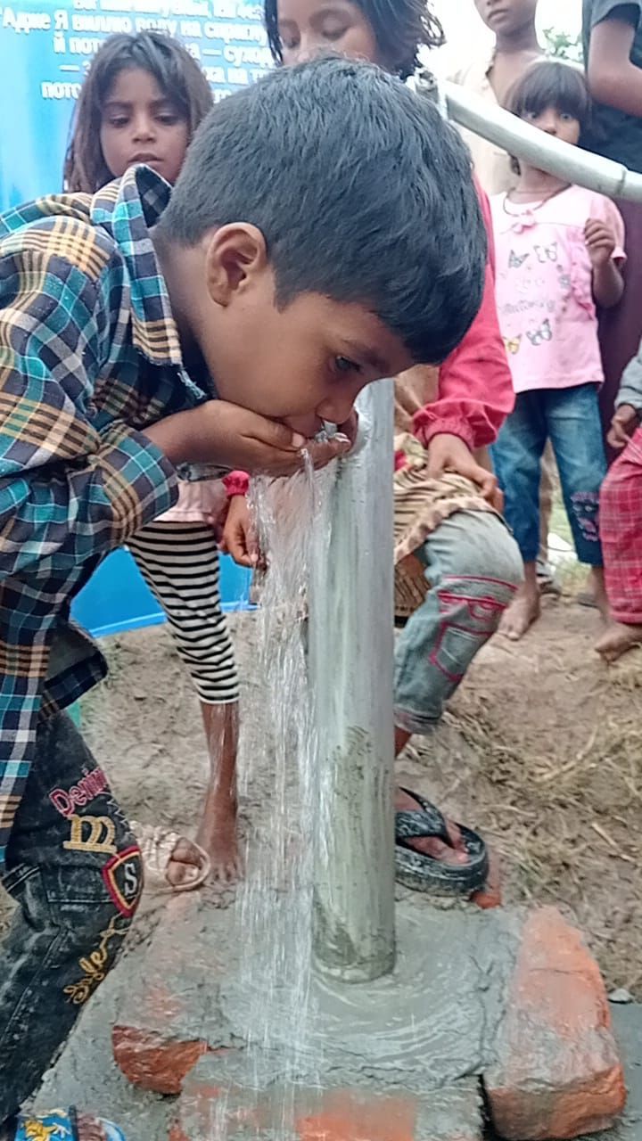 Boy drinking from water pump